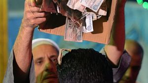 رجل يحتفل بأحد المتزوجين في مصر بإلقاء المال على رأسه- جيتي