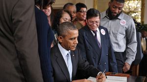أوباما أثناء التوقيع - أ ف ب
