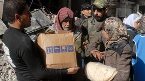 من تقديم المساعدات في مخيم اليرموك - ا ف ب