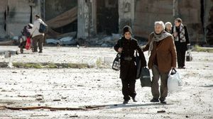 مدنيون سوريون أثناء مغادرتهم مدينة حمص المحاصرة (أرشيفية) - أ ف ب