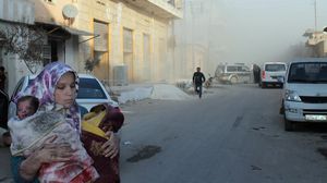 سيدة تنجو من القصف مع أطفالها في حلب - الأناضول
