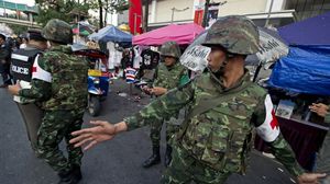 جنود تايلانديون يتفقدون موقعا للمعارضة عقب انفجار وقع الأحد - ا ف ب