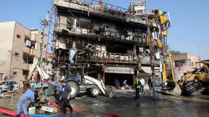 رجال إطفاء وعمال ينظفون موقع انفجار في مبنى تجاري ببغداد - ارشيفية- ا ف ب