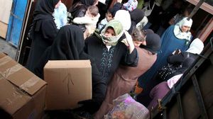 سوريون خلال توزيع مساعدات - أرشيفية