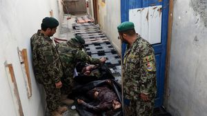 جنود أفغان يتفقدون قتلى العمليات الأمنية - ا ف ب