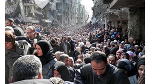 صورة وزعتها الأمم المتحدة لتجمع السكان في مخيم اليرموك المحاصر للحصول على المساعدات الغذائية