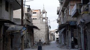 يستخدم رجل العكازات في أحد الأحياء المحاصر بمدينة حمص – أ ف ب