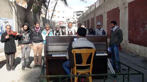 شباب يتجاهلون الدمار ويعزفون الموسيقى في مخيم اليرموك بدمشق - الأناضول