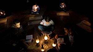 أطفال غزيون يدرسون على ضوء الشموع بسبب أزمة الكهرباء (أرشيفية) - الأناضول