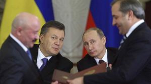 الرئيس الروسي فلاديمير بوتين (وسط يمين) بجانبه الرئيس الأوكراني فيكتور يانوكوفيتش - أ ف ب