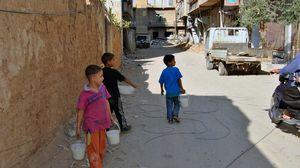 أطفال في داريا يحملون بعض الطعام من المطبخ الميداني (صورة خاصة لـ"عربي21" - بعدسة علاء عرنوس)