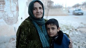 الطفل السوري حسين الحسن إلى جانب والدته في مدينة كليس التركية- الأناضول 