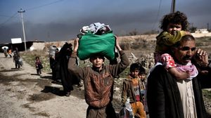 مدنيون فارون من مناطق القتال في الموصل- أ ف ب 