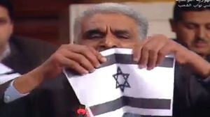 قام النائب بتمزيق علم إسرائيل وهتف باسم فلسطين قائلا: "عاشت فلسطين وعاشت الثورة الفلسطينية" - يوتيوب