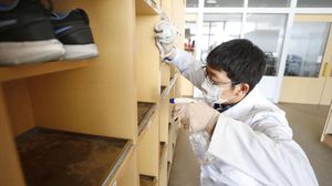 عامل ياباني يقوم بتعقيم خزائن في إحدى المؤسسات لمكافحة المرض- وكالة كيودو اليابانية