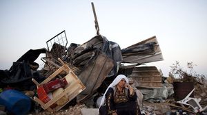 فلسطينية تجلس قرب بيتها المدمر في العراقيب جنوب فلسطين المحتلة  
