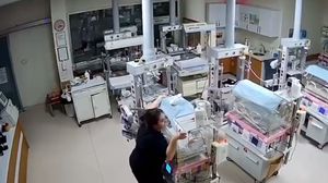 واحدة من الممرضات وهي تمسك بحضانة حديثي ولادة خلال الهزة العنيفة- تويتر