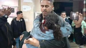 الفنان الفلسطيني محمود زعيتر يحمل ابنة شقيقته المصابة بعد قصف منزلهم- إكس