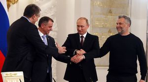 بوتين بعد توقيعه الاتفاق مع القادة الجدد الموالين للروس في القرم - أ ف ب