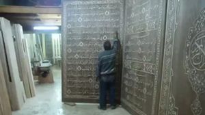 اللاجئ السوري يعمل على ألواح الخشب لعمل أكبر مصحف - (أرشيفية)