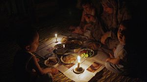 عائلة مصرية تتناول طعامها على ضوء الشموع - (أرشيفية)