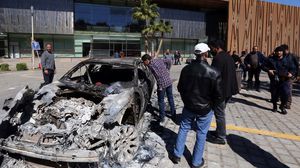 سيارة محترقة أمام المؤتمر الوطني الليبي بعد هجوم مسلحين عليه - أ ف ب
