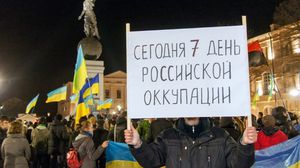 أوكرانيون في مدينة خاركيف الشرقية يرفعون لافتة تقول "اليوم هو السابع للاحتلال الروسي" - ا ف ب