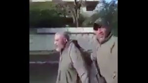 جندي عراقي يجر رجلا مسنا- من الفيديو