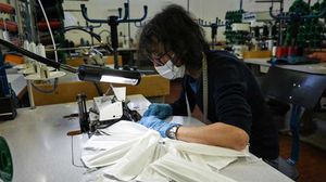 بدأت شركة في منطقة بييمونتي الإيطالية لصناعة الملابس الفاخرة إنتاج أقنعة قماشية للاستجابة للنقص في هذه السلعة- أ ف ب 