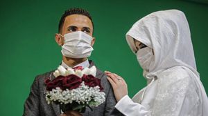 العريس الفلسطيني محمد أبو  دقة يرتدي الكمامة هو وعروسه خلال حفل زفافهما في قطاع غزة- تويتر