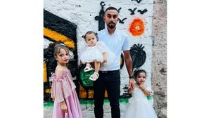 أحمد إلى جانب بناته اللاتي استشهدن بالعدوان - بي بي سي 