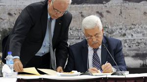 عباس وعريقات خلال التوقيع على وثائق الانضمام للمنظمات الدولية - أ ف ب