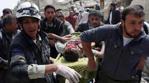 سوريون يحملون شابا بعد إصابته في حلب - ا ف ب