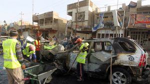 عمال نظافة عراقيون يزيلون حطام سيارات محطمة - ارشيفية- ا ف ب