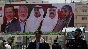 لافتة رفعت في غزة تحمل صور شخصيات سياسية الشهر الماضي - الأناضول