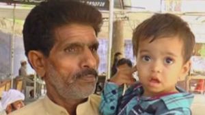 الرضيع يحمله والده بعد أخذ بصماته من قبل القضاء الباكستاني - يوتيوب