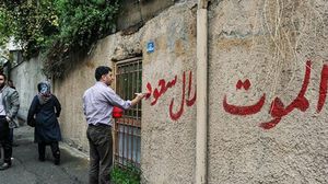 محتج إيراني يخط عبارات مناهضة للنظام السعودي على جدار سفارته في طهران - أرشيفية