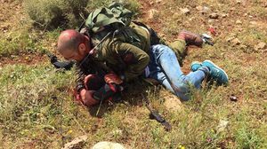 الجندي الإسرائيلي يعتقل الشاب بعد طعنه برأسه - فيسبوك