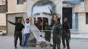 مقاتلون أكراد يمزقون صورة لبشار الأسد في القامشلي - عنب بلدي