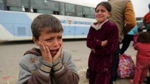 أطفال نازحون من الموصل بعد مقتل والدهم كما قالوا على يد تنظيم الدولة خلال محاولة نزوحه- أ ف ب
