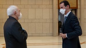 الأسد استقبل ظريف في قصر الرئاسة بالكمامة وكذلك وصل ظريف مرتديا قفازا وكمامة- جيتي