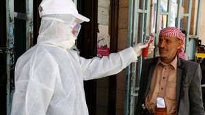 موظف صحي في صنعاء يفحص حرارة مراجعين لمركز صحي- جيتي
