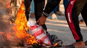 شبان عراقيون يحرقون العلم الأمريكي في إحدى التظاهرات- جيتي