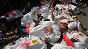 نشطاء في لوحة تعبيرية عن الضحايا الذين سقطوا في مذبحة رابعة- جيتي