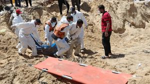 عناصر الدفاع المدني الفلسطيني خلال انتشال جثامين الشهداء من المقبرة الجماعية- إكس
