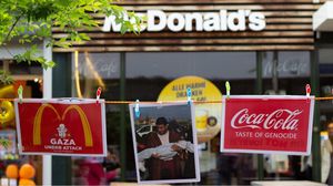 وزع المتظاهرون منشورات على المارة أمام "ماكدونالدز" بهدف تسليط الضوء على المجازر الإسرائيلي بحق الفلسطينيين- الأناضول