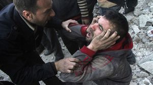 سوريون على أنقاض منازلهم التي قصفت بالبراميل المتفجرة - ا ف ب