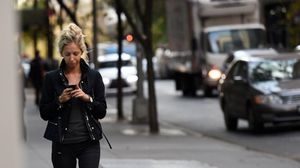 أمريكية تستخدم هاتفها الذكي في نيويورك - أ ف ب