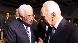 رئيس السلطة الفلسطينية محمود عباس يصافح الرئيس الإسرائيلي السابق شمعون بيريز - أ ف ب