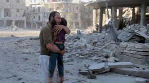 أحد سكان حلب يحمل جثة ابنه الذي قضى بالقصف- تويتر